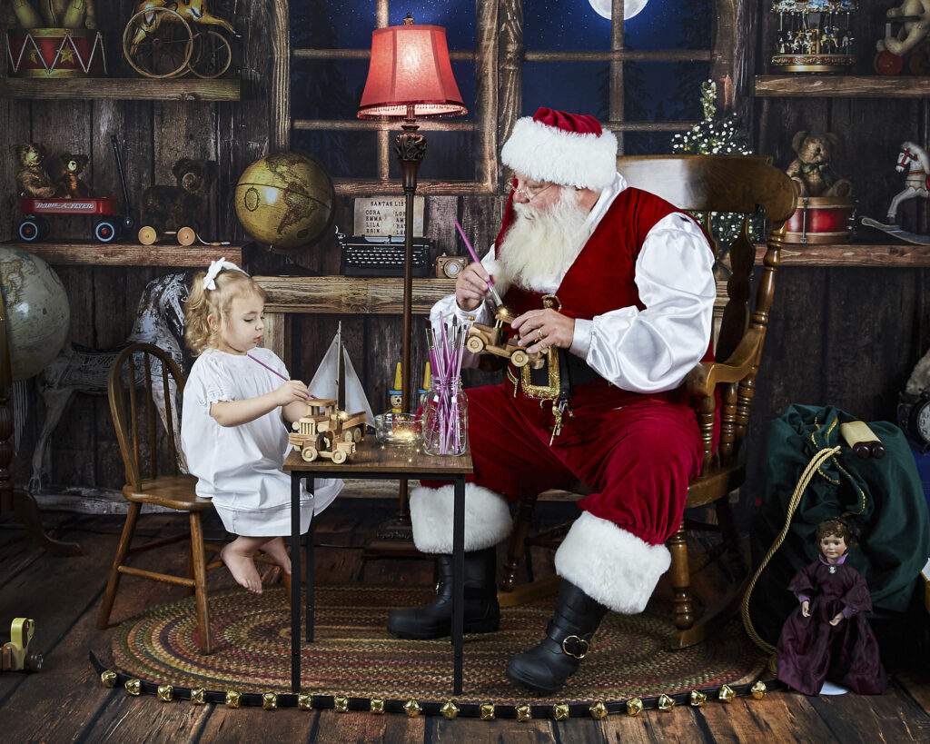 Santa with young girl painting toys